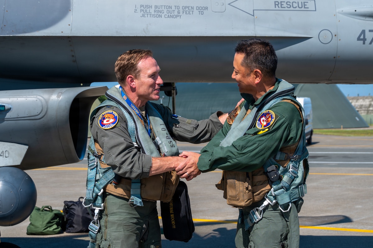 U.S. Air Force Col. Paul “Voodoo” Davidson, 35th Fighter Wing commander, left, and Japan Air Self-Defense Force (JASDF) Maj. Gen. Teru “Beacon” Tomikawa, 3rd Air Wing commander, shake hands following a familiarization flight at Misawa Air Base, Japan, June 30, 2026