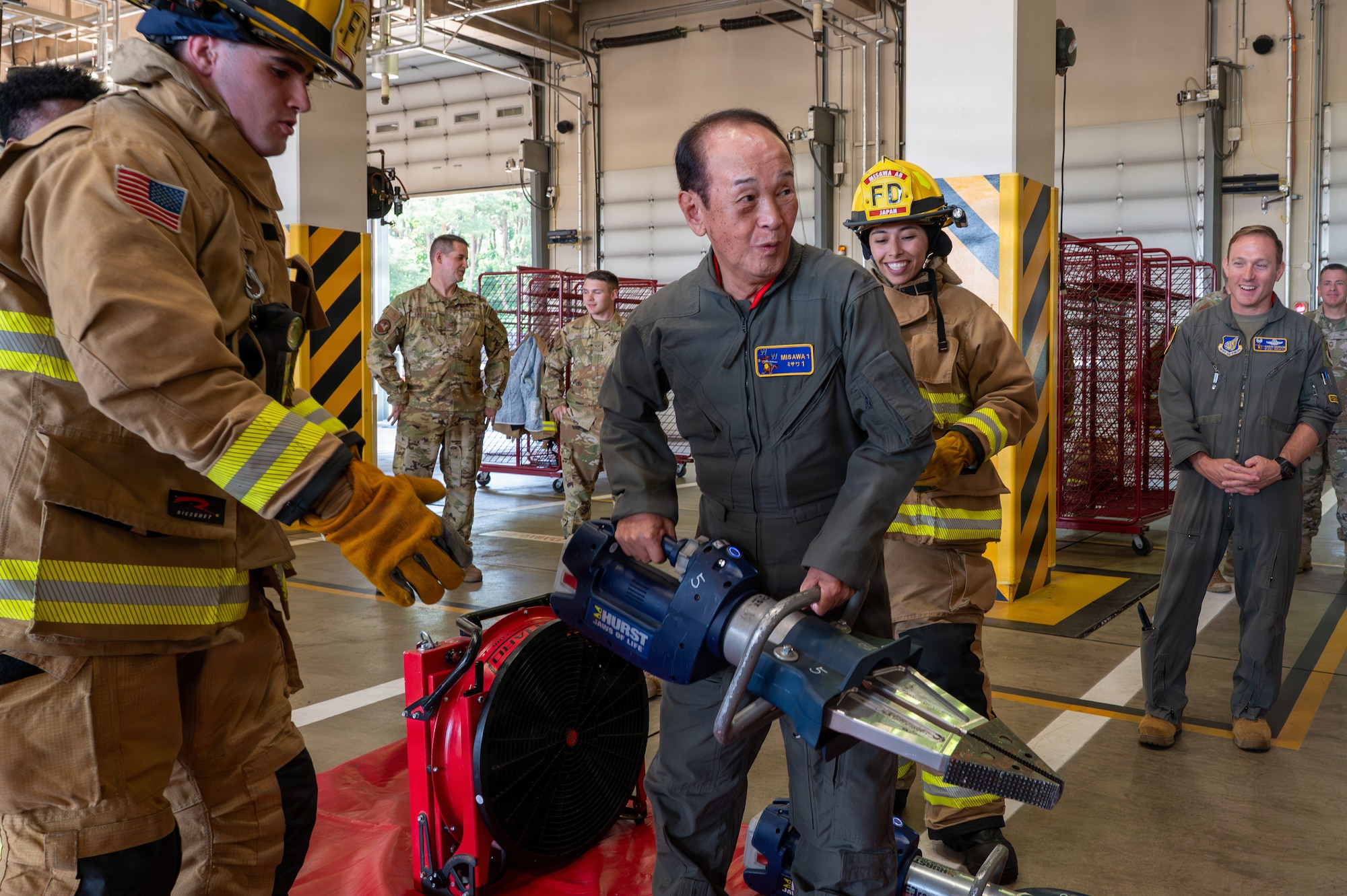 Misawa City Mayor Yoshinori Kohiyama participates in a hydraulic rescue tool demonstration during a Wing Commander for a Day tradition at Misawa Air Base, Japan, July 1, 2026