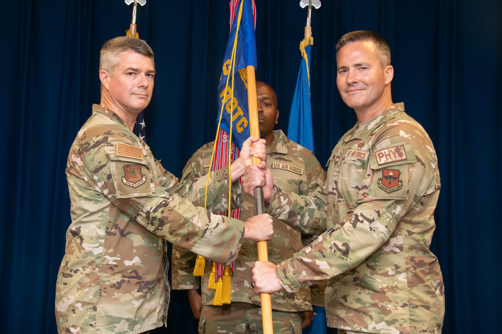 Two servicemembers exchange a guidon