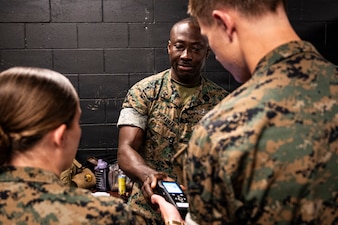 U.S. Navy corpsmen and medical officers from across the II Marine Expeditionary Force get hands-on with a TBI assessment device during an end-user touchpoint at the Tactical Medicine Training Center, Camp Lejeune, North Carolina, June 30, 2026. The event brought together U.S. Navy corpsmen and medical officers from across the II Marine Expeditionary Force to assess new capabilities for evaluating traumatic brain injuries on the battlefield. Participants evaluated Traumatic Brain Injury Field Assessment Program devices in a hands-on session, giving TBI-FAP developers critical feedback directly from the frontline medical providers who may one day use the equipment in austere environments. (Defense Health Agency Photo by T. T. Parish/Released)