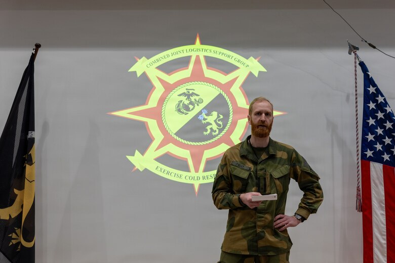 Norwegian army Maj. Stain Tajet, a planning officer with the exercise Cold Response 26 Combined Joint Logistics Support Group, gives opening remarks during a transfer of authority ceremony at Kjeller Air Base, Norway, Feb. 27, 2026. The ceremony transferred command of the CJLSG from Norwegian army Brig. Gen. Nina S. Berg to U.S. Marine Corps Brig. Gen. Maura M. Hennigan. A key component of NATO's enhanced vigilance activity Arctic Sentry, exercise Cold Response 26 is a Norwegian-led winter military exercise designed to enhance collective defense capabilities and ensure U.S. readiness to rapidly deploy and seamlessly operate alongside NATO Allies in challenging arctic conditions. (U.S. Marine Corps photo by Sgt. Rafael Brambila-Pelayo)
