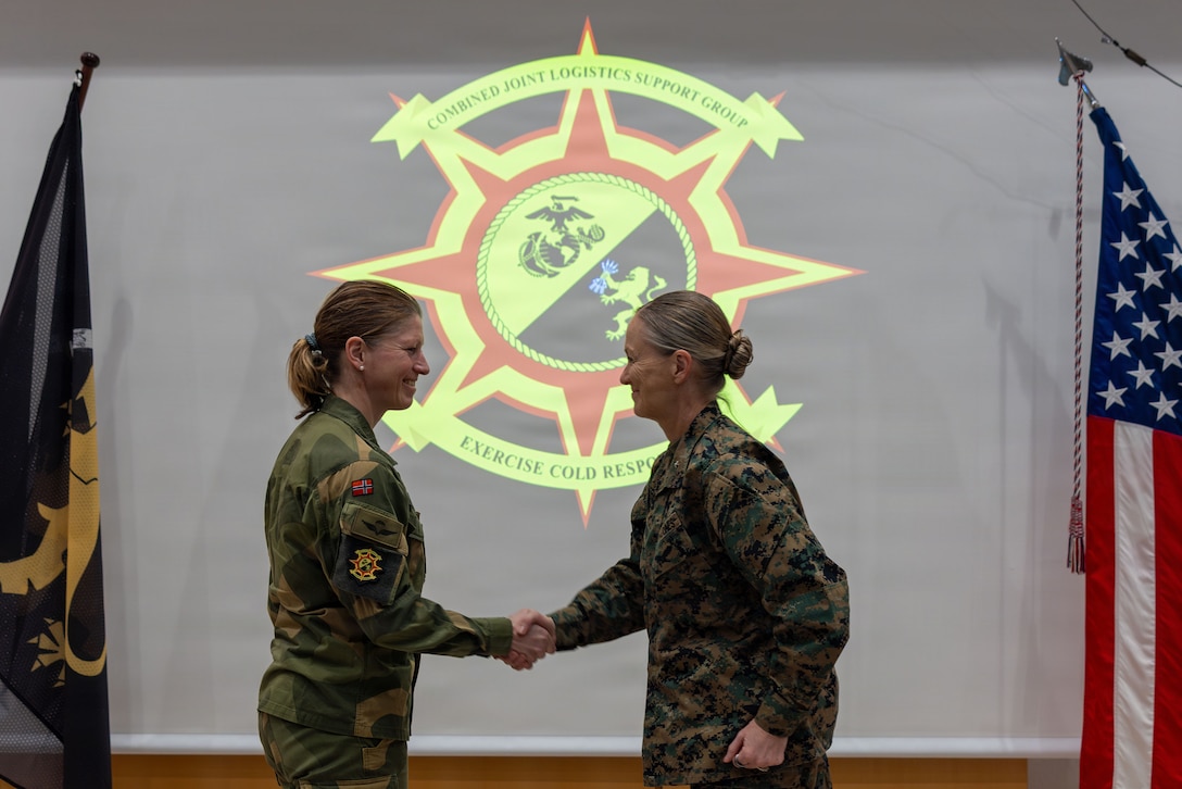 Norwegian army Brig. Gen. Nina S. Berg, left, outgoing commander of the exercise Cold Response 26 Combined Joint Logistics Support Group, shakes hands with U.S. Marine Corps Brig. Gen. Maura M. Hennigan, incoming commander, during a transfer of authority ceremony at Kjeller Air Base, Norway, Feb. 27, 2026. A key component of NATO's enhanced vigilance activity Arctic Sentry, exercise Cold Response 26 is a Norwegian-led winter military exercise designed to enhance collective defense capabilities and ensure U.S. readiness to rapidly deploy and seamlessly operate alongside NATO Allies in challenging arctic conditions. (U.S. Marine Corps photo by Sgt. Rafael Brambila-Pelayo)
