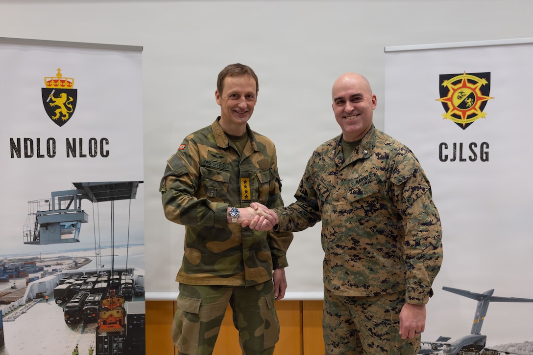Norwegian army Chief of Defence Gen. Eirik Kristoffersen, left, gives a challenge coin to U.S. Marine Corps Lt. Col. Sean Day, the deputy chief of staff for the Combined Joint Logistics Support Group during a tour of the CJLSG prior to exercise Cold Response 26 in Kjeller, Norway, Feb. 23, 2026. A key component of NATO's enhanced vigilance activity Arctic Sentry, exercise Cold Response 26 is a Norwegian-led winter military exercise designed to enhance collective defense capabilities and ensure U.S. readiness to rapidly deploy and seamlessly operate alongside NATO Allies in challenging arctic conditions. (U.S. Marine Corps Photo by Sgt. Rafael Brambila-Pelayo)