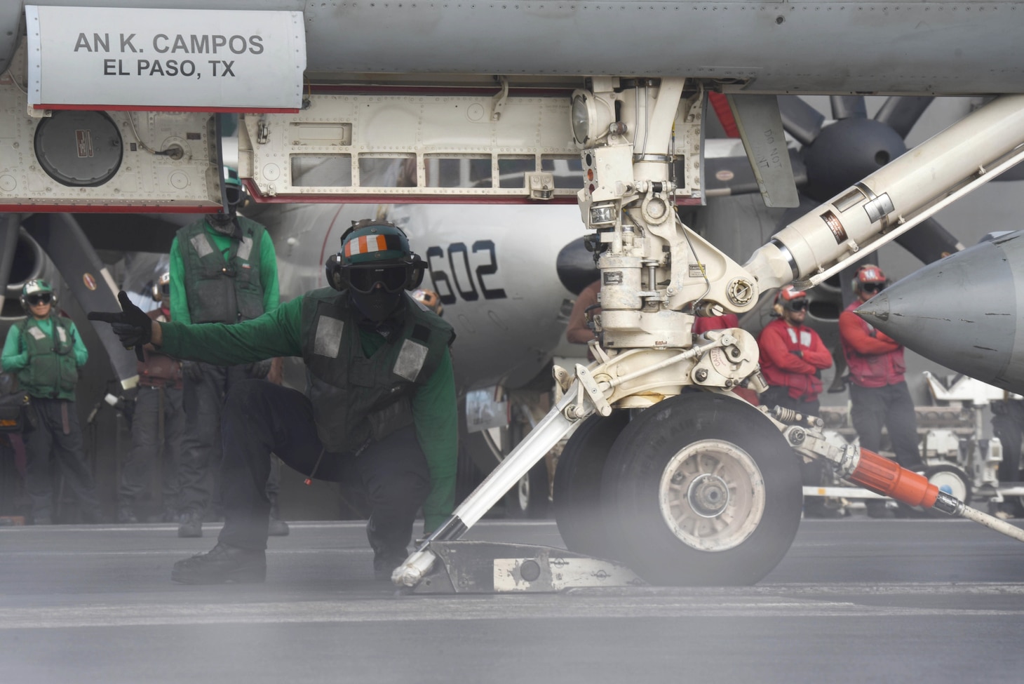 Aviation Boatswain's Mate (Equipment) 3rd Class Darius Jarmon assists an F/A-18 Super Hornet load onto a catapult on the flight deck aboard the Nimitz-class aircraft carrier USS Harry S. Truman (CVN 75).