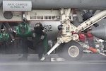 Aviation Boatswain's Mate (Equipment) 3rd Class Darius Jarmon assists an F/A-18 Super Hornet load onto a catapult on the flight deck aboard the Nimitz-class aircraft carrier USS Harry S. Truman (CVN 75).