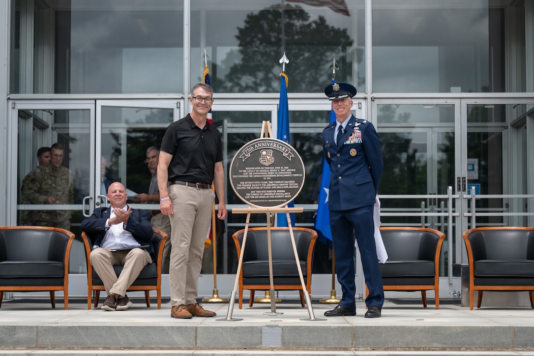 Air Force Test Center Commander and former Arnold Engineering Development Complex commander Maj. Gen. Scott Cain, standing left, and outgoing AEDC Commander Col. Grant Mizell, right, unveil a plaque commemorating the rededication of the Complex during the AEDC 75th anniversary open house celebration June 27, 2026, at Arnold Air Force Base, Tenn., headquarters of AEDC. AEDC was originally dedicated by then-President Harry S. Truman on June 25, 1951, in honor of the late Gen. Henry “Hap” Arnold. (U.S. Air Force photo by Keith Thornburgh)