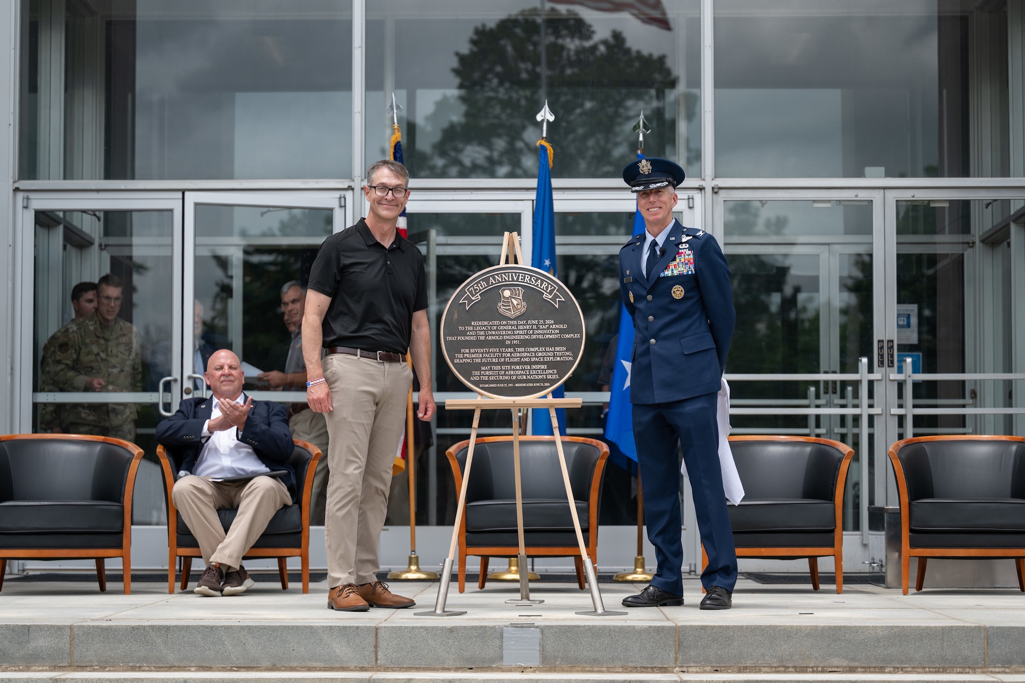 Air Force Test Center Commander and former Arnold Engineering Development Complex commander Maj. Gen. Scott Cain, standing left, and outgoing AEDC Commander Col. Grant Mizell, right, unveil a plaque commemorating the rededication of the Complex during the AEDC 75th anniversary open house celebration June 27, 2026, at Arnold Air Force Base, Tenn., headquarters of AEDC. AEDC was originally dedicated by then-President Harry S. Truman on June 25, 1951, in honor of the late Gen. Henry “Hap” Arnold. (U.S. Air Force photo by Keith Thornburgh)