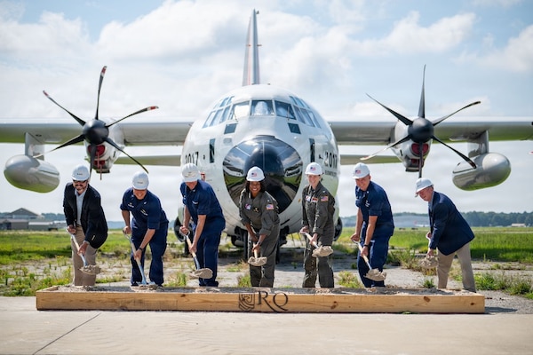 Coast Guard breaks ground on new runway with a Coast Guard airplane in the background.