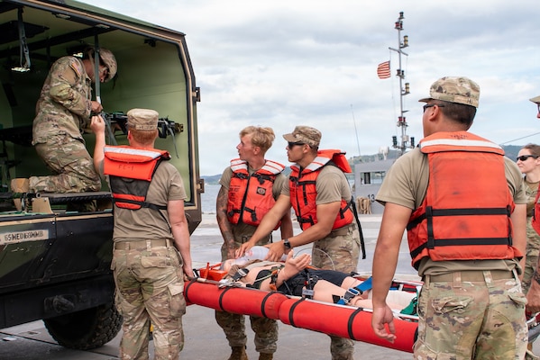 U.S. Army medics load a simulated casualty on a litter into the back of a medical evacuation vehicle during a CJLOTS 26 casualty evacuation training exercise at Trident Pier.