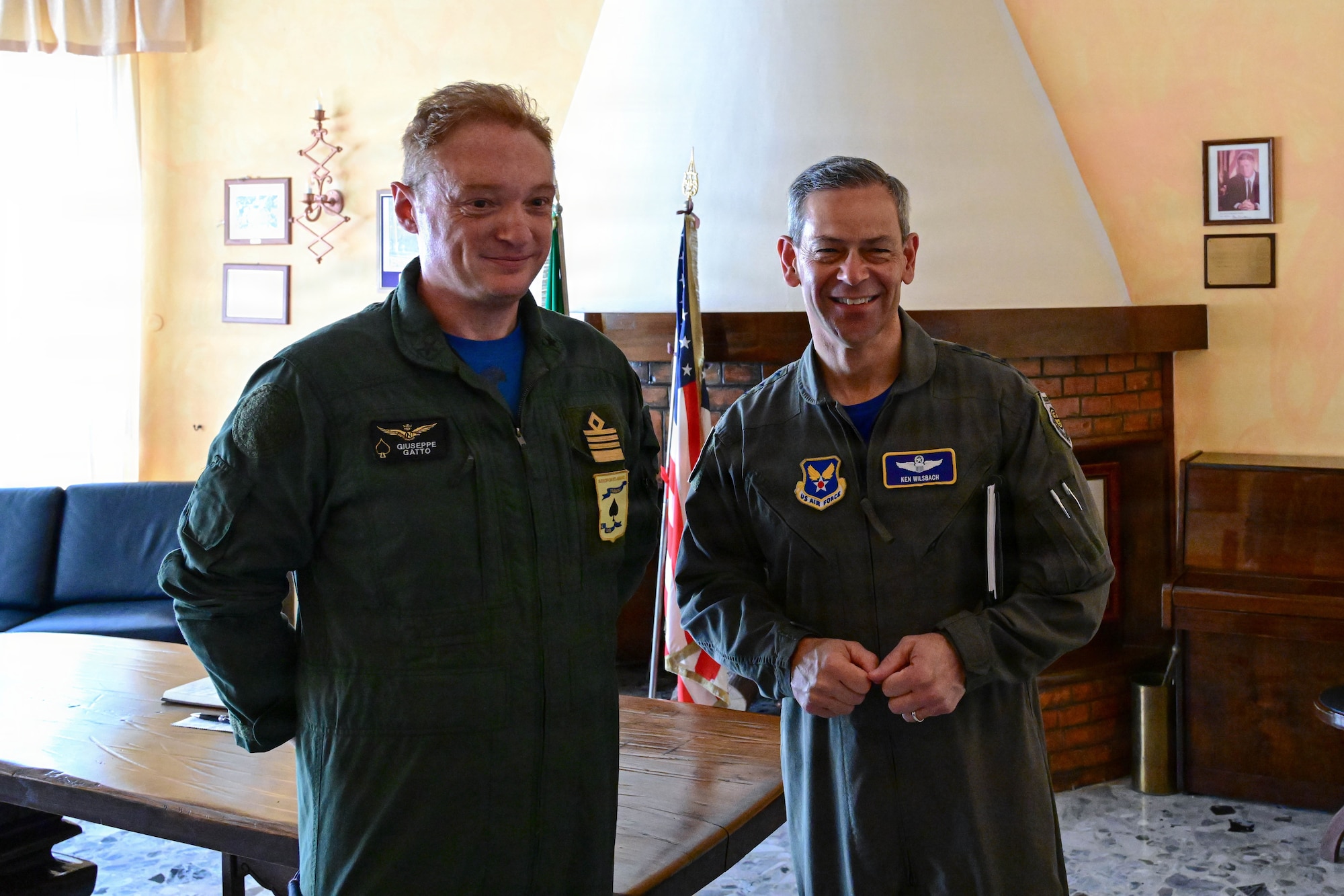 Two men pose together for a photo inside.