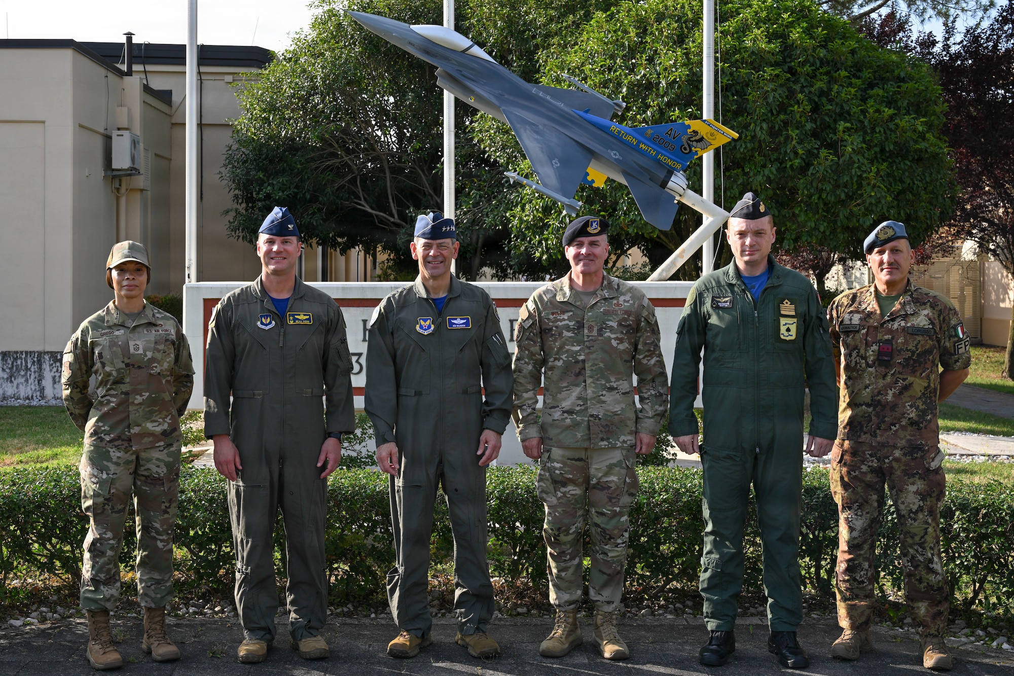 A group stands together outside for a photo.