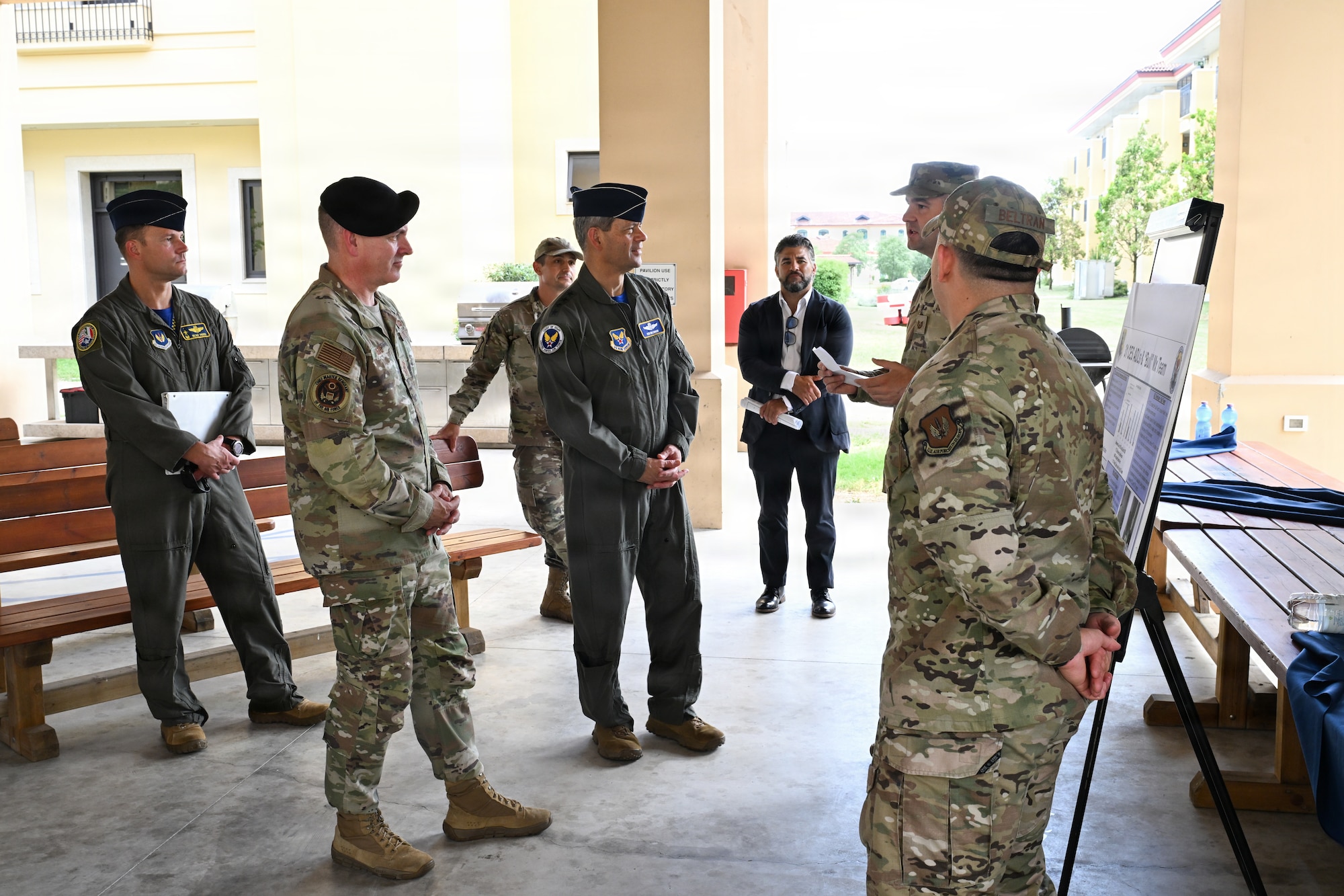 Two men listen to a brief from another man.