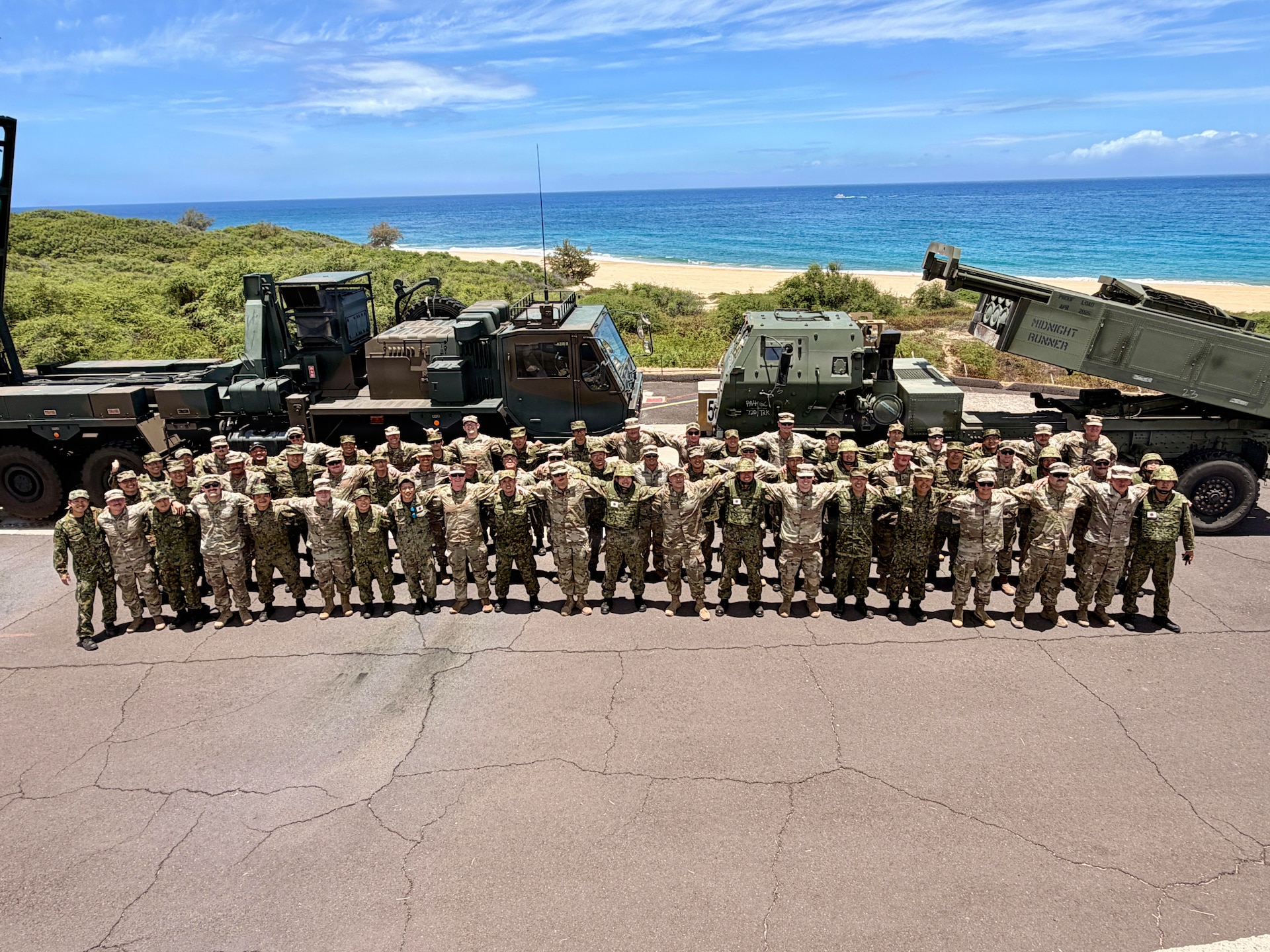 Kentucky National Guardsmen with the 1st Battalion, 623rd Field Artillery Regiment gather with members of the Japanese Ground Self Defense Force after the final rounds were fired of a combined live-fire exercise during Exercise Rim of the Pacific 2026 in Pacific Missile Range Facility Barking Sands in Kauai, Hawaii, July 12, 2026.