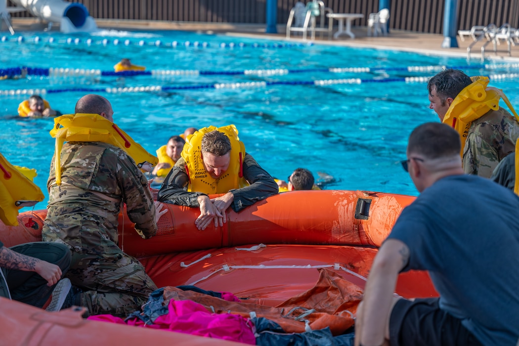 U.S. Air Force Airmen assigned to Altus Air Force Base (AFB) climb on to a life raft during Water Survival Training at Altus AFB, Oklahoma, July 10, 2026. This initiative allowed 56 Altus AFB Airmen to regain certification in water survival. (U.S. Air Force photo by Airman 1st Class Emma Wright