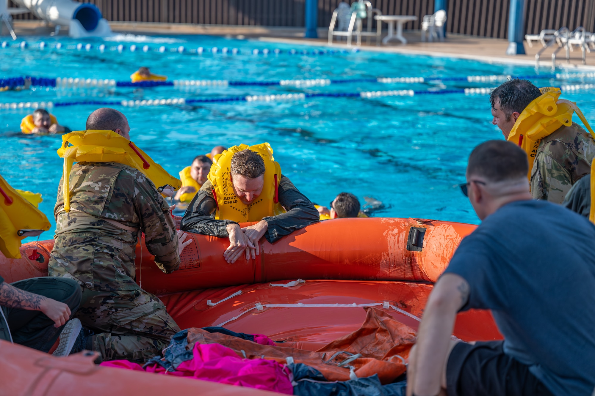 U.S. Air Force Airmen assigned to Altus Air Force Base (AFB) climb on to a life raft during Water Survival Training at Altus AFB, Oklahoma, July 10, 2026. This initiative allowed 56 Altus AFB Airmen to regain certification in water survival. (U.S. Air Force photo by Airman 1st Class Emma Wright