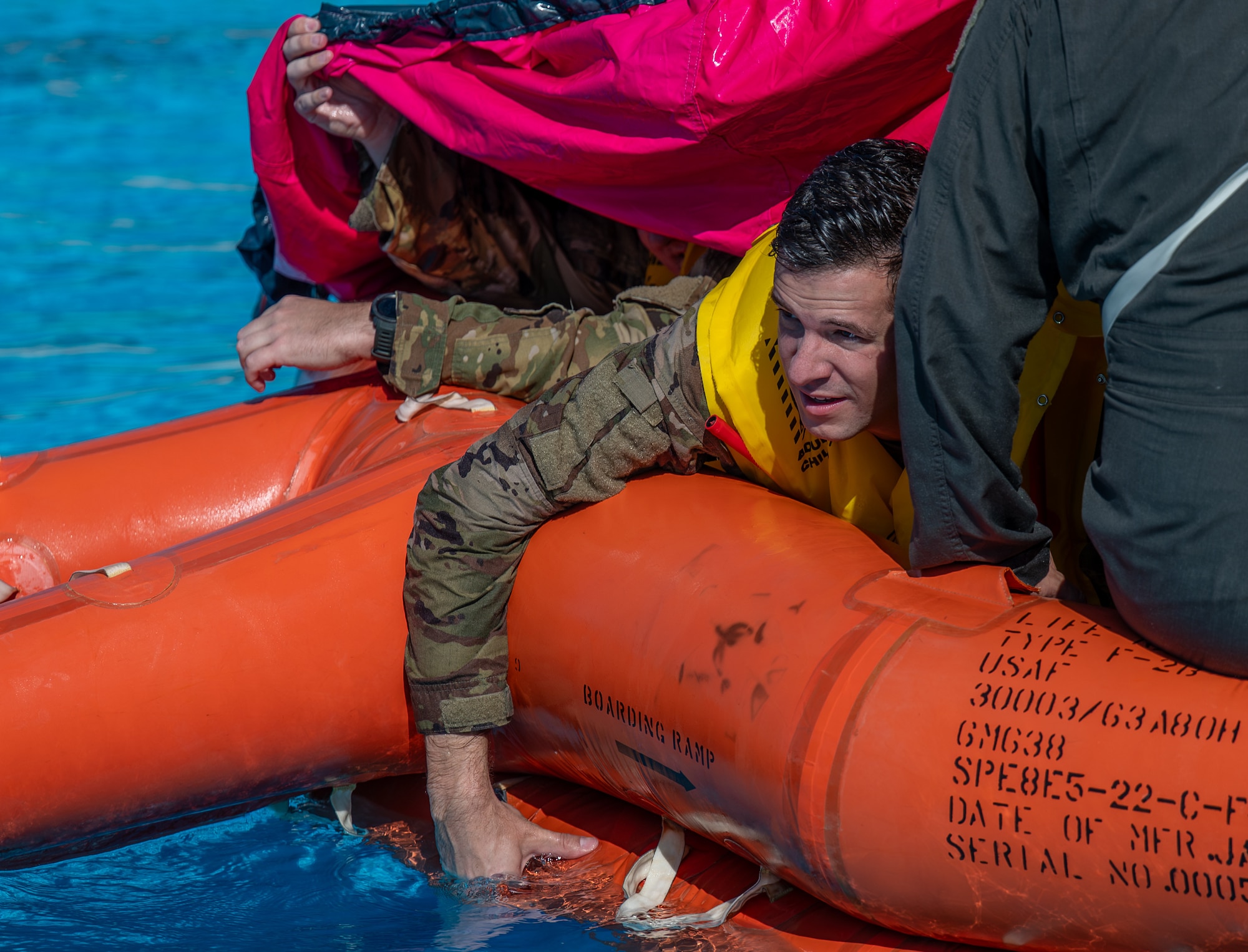 U.S. Air Force Capt. Dustin Jarvis, 58th Airlift Squadron C-17 formal training unit instructor, works to secure a canopy over a life raft during Water Survival Training at Altus Air Force Base (AFB), Oklahoma, July 10, 2026. In the Altus AFB pool, survival, evasion, resistance, and escape specialists drilled participants on utilizing life rafts. (U.S. Air Force photo by Airman 1st Class Emma Wright)