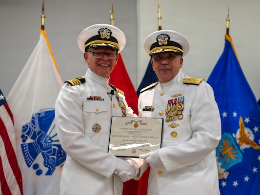 (260710-N-AJ782-1288) FALLS CHURCH, Va. From left to right, U.S. Navy Capt. Lonnie S. Hosea, U.S. Navy Bureau of Medicine and Surgery (BUMED) senior health policy advisor, is awarded with the Defense Meritorious Service Medal by Rear Adm. Matthew Case, acting Surgeon General of the Navy and acting chief, BUMED, as part of a joint retirement and commissioning ceremony at Defense Health Headquarters in Falls Church, Virginia, July 10, 2026. Hosea and his daughter, Ensign Jenna Hosea Baker, who is a nurse assigned to Walter Reed National Military Medical Center, highlighted a continuing legacy of service for Navy Medicine as Hosea closed out a 30-year career and Baker took her first steps into the Nurse Corps. (U.S. Navy photo by Kevin Ray J. Salvador)