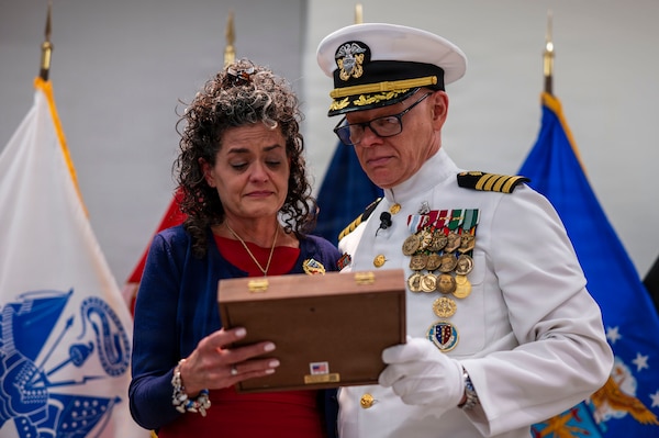 (260710-N-AJ782-1332) FALLS CHURCH, Va. From left to right, Deanna McAlister Hosea receives the Military Spouse Medal from her husband, U.S. Navy Capt. Lonnie S. Hosea, Bureau of Medicine and Surgery senior health policy advisor, as part of a joint retirement and commissioning ceremony at Defense Health Headquarters in Falls Church, Virginia, July 10, 2026. Hosea and his daughter, Ensign Jenna Hosea Baker, who is a nurse assigned to Walter Reed National Military Medical Center, highlighted a continuing legacy of service for Navy Medicine as Hosea closed out a 30-year career and Baker took her first steps into the Nurse Corps. (U.S. Navy photo by Kevin Ray J. Salvador)