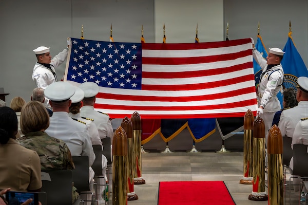 (260710-N-AJ782-1471) FALLS CHURCH, Va. The U.S. Navy Ceremonial Guard performs the 13 Folds as part of a joint ceremony featuring the retirement of Capt. Lonnie S. Hosea, Bureau of Medicine and Surgery senior health policy advisor, and the commissioning of Ensign Jenna Hosea Baker, a nurse assigned to Walter Reed National Military Medical Center, at Defense Health Headquarters in Falls Church, Virginia, July 10, 2026. The ceremony highlighted a continuing legacy of service for Navy Medicine as Hosea closed out a 30-year career and Baker took her first steps into the Nurse Corps. (U.S. Navy photo by Kevin Ray J. Salvador)