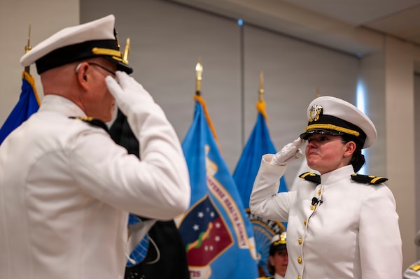 (260710-N-AJ782-1606) FALLS CHURCH, Va. From left to right, U.S. Navy Capt. Lonnie S. Hosea, Bureau of Medicine and Surgery senior health policy advisor, salutes his daughter, Ensign Jenna Hosea Baker, a nurse assigned to Walter Reed National Military Medical Center, as part of a joint ceremony featuring the retirement of Hosea and the commissioning of Baker at Defense Health Headquarters in Falls Church, Virginia, July 10, 2026. The ceremony highlighted a continuing legacy of service for Navy Medicine as Hosea closed out a 30-year career and Baker took her first steps into the Nurse Corps. (U.S. Navy photo by Kevin Ray J. Salvador)