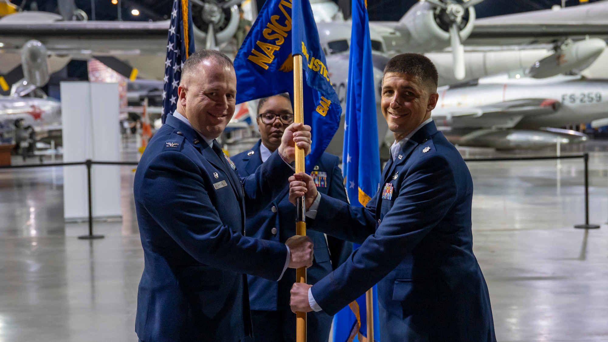 Col. John Minear, left passes the guidon to Lt. Col. Jasen Little during a change of command ceremony.