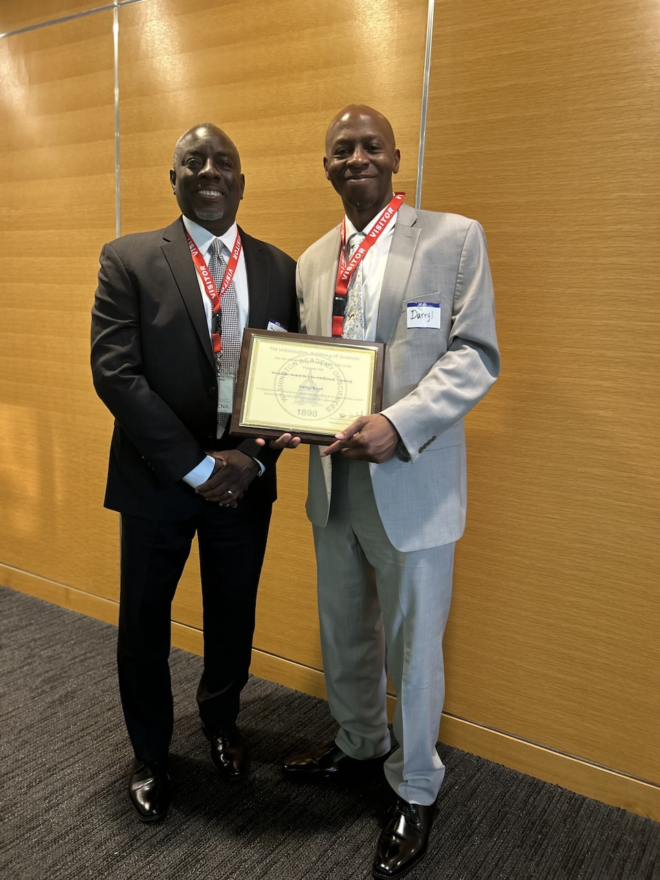 U.S. Naval Research Laboratory (NRL) NRL Center for Biomolecular Science and Engineering Research Chemist Paul Charles (left) supports NRL Chemist Darryl Boyd, Ph.D., (right) who received the Washington Academy of Sciences Krupshaw Award for Non-Traditional Teaching during an awards ceremony held at the Center for Naval Analysis in Arlington, Virginia, May 7, 2026, for his extensive and comprehensive efforts as a science teacher, mentor and Science, Technology, Engineering, and Math (STEM) advocate in the Washington, D.C., metro area. (U.S. Navy photo)