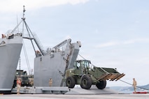 A military 624K wheel loader offloads from a Logistics Support Vessel onto Trident Pier during CJLOTS operations in Pohang, South Korea.