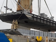 A crane aboard the Ocean Giant vessel lifts a Modular Warping Tug into the water at Pohang Port, South Korea, during CJLOTS 26.