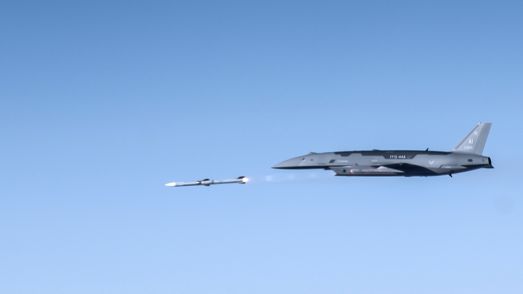 A YFQ-44A Collaborative Combat Aircraft fires an AIM-120 weapon in secluded airspace over the Mojave Desert. The live-fire test of the YFQ-44 aircraft is the latest milestone in the rapid development of safe and effective CCA operations. (U.S. Air Force photo by Jennifer Healy)