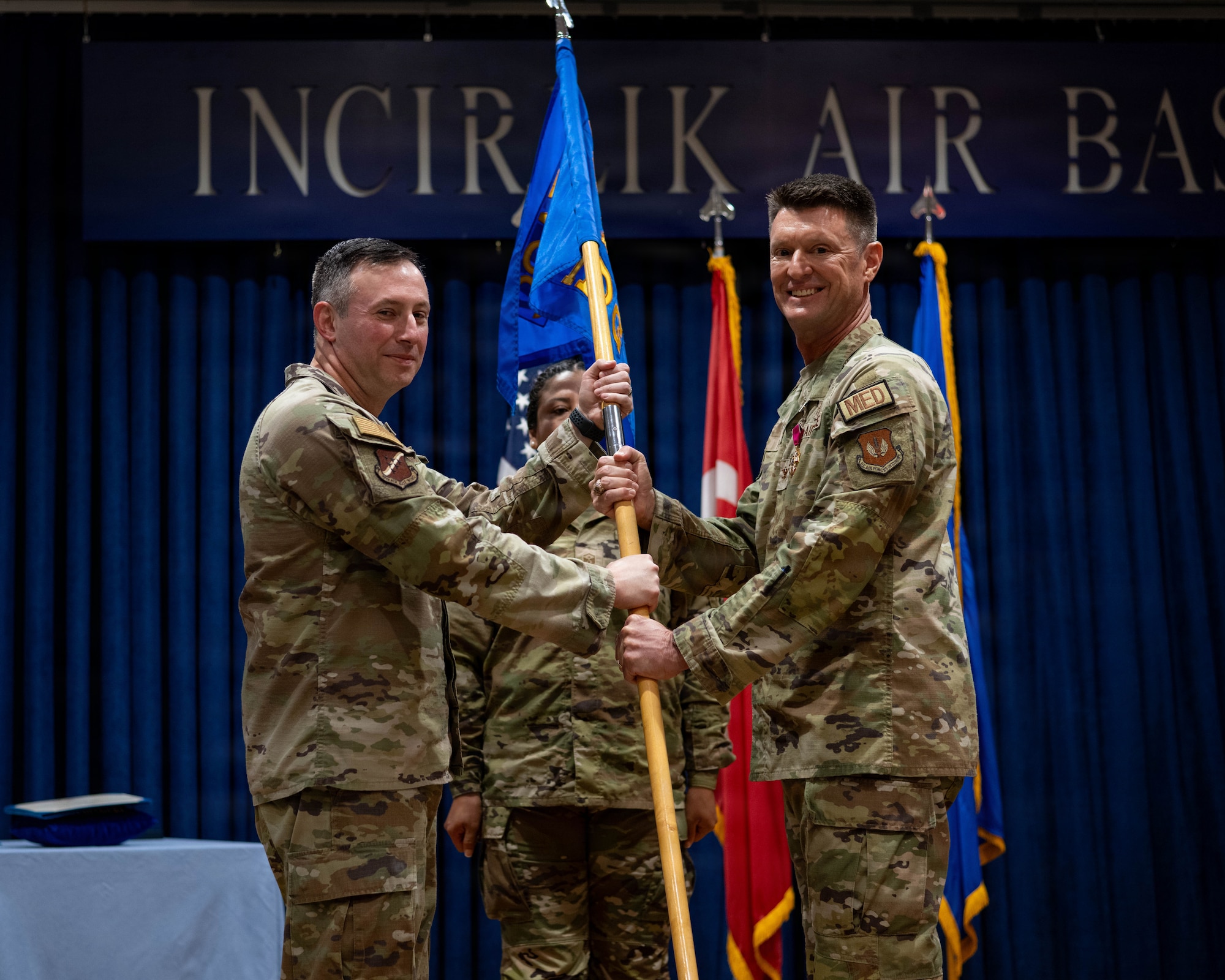 U.S. Air Force Col. Isaac Adams, 39th Air Base Wing commander, receives the guidon from Col. Craig Rhyne, 39th Medical Group outgoing commander, to relinquish command.