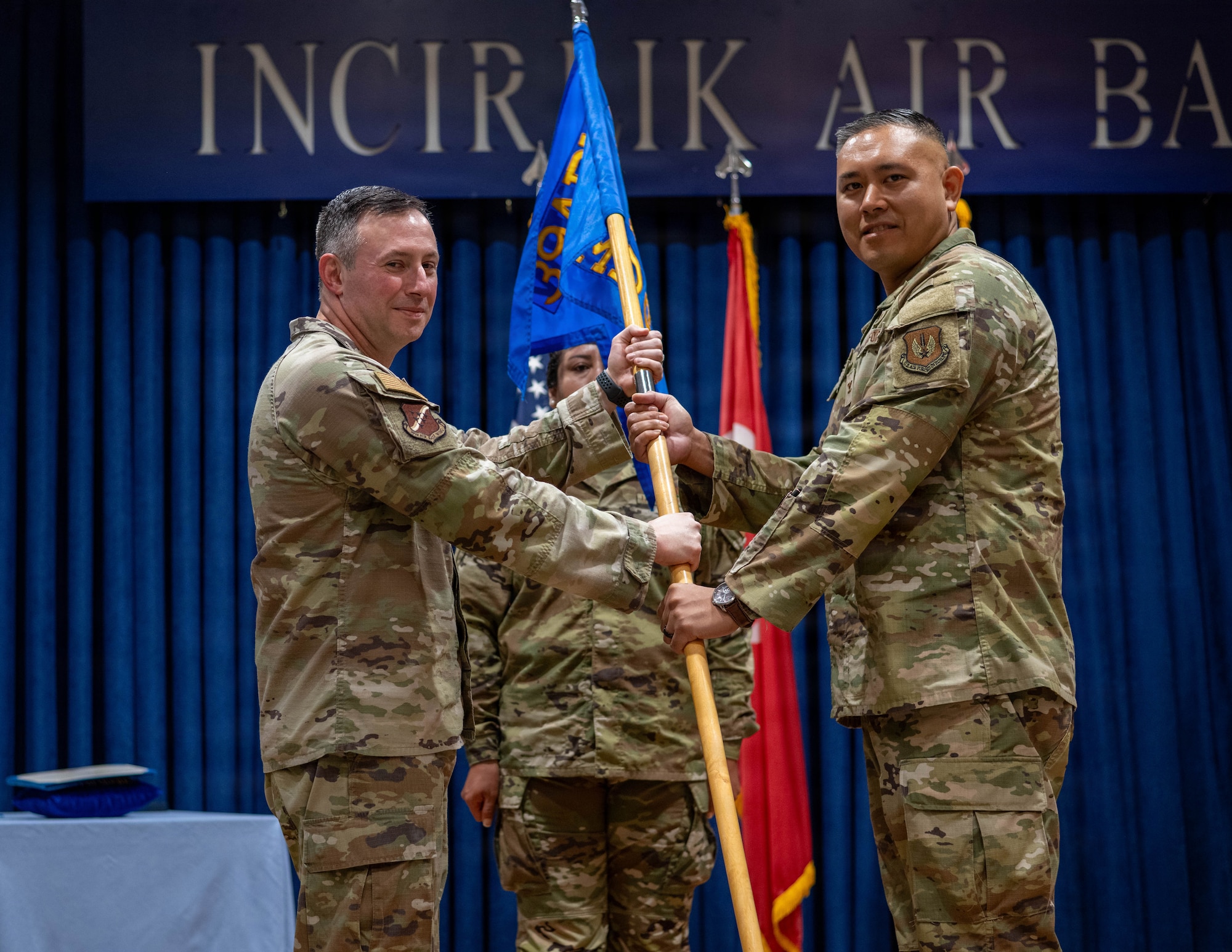 U.S. Air Force Col. Isaac Adams, 39th Air Base Wing commander, passes the guidon to Col. David Dy, 39th Medical Group incoming commander,