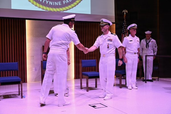 Cmdr. William “PJ” Martin (right) shakes hands with Lt. Cmdr. Alex R. Stulo (left) to acknowledge the transfer of leadership during a change of charge ceremony for Navy Medicine Readiness and Training Unit China Lake at Naval Air Weapons Station China Lake, California, July 10, 2026. (U.S. Navy photo by NAWS China Lake public affairs).