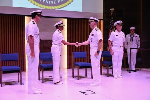 Capt. Janiese Cleckley (center), commanding officer of Navy Medicine Readiness and Training Command Twentynine Palms, shakes hands with Cmdr. William “PJ” Martin (right) to acknowledge the relinquishment of charge of Navy Medicine Readiness and Training Unit China Lake during a change of charge ceremony at Naval Air Weapons Station China Lake, California, July 10, 2026. (U.S. Navy photo by NAWS China Lake public affairs).