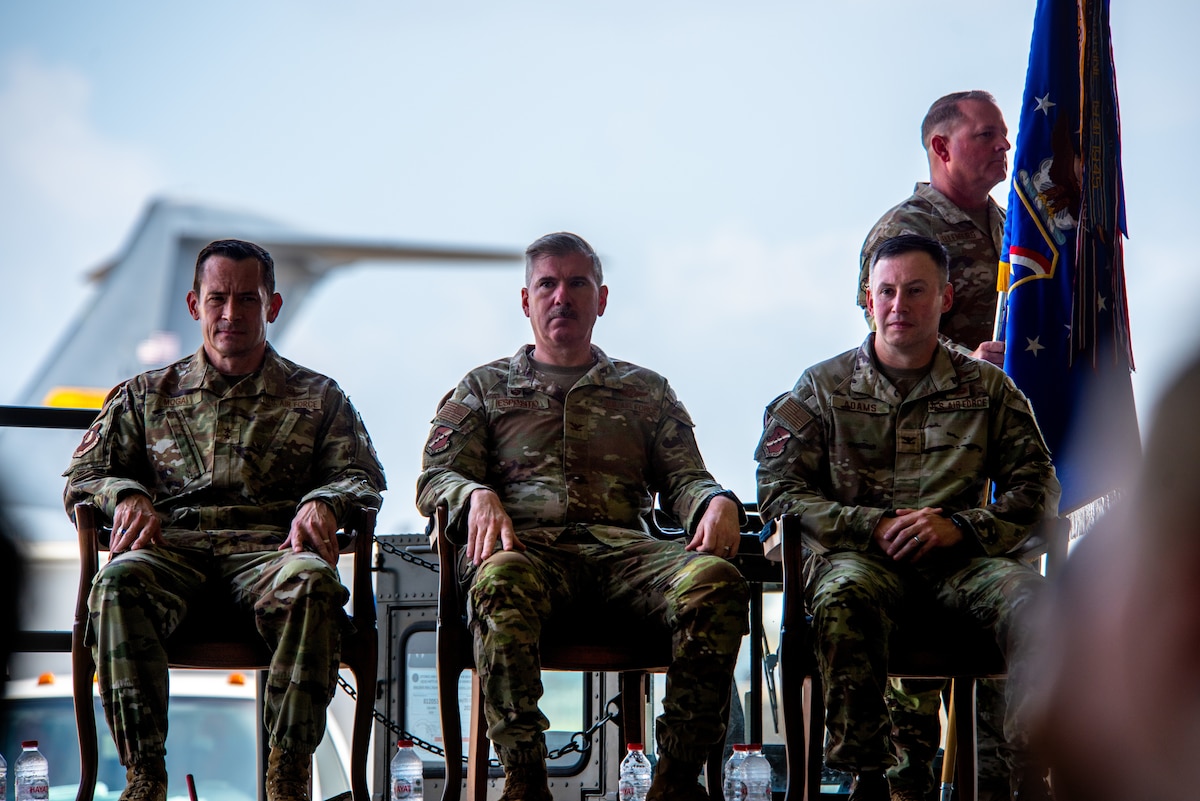 Three men sit in a chair.