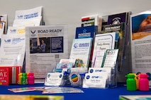 Informational brochures and infographics of family support, deployment, and childcare programs are arranged on a table.