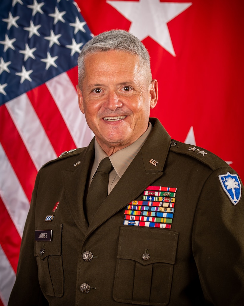 MG Jones command photo, sitting in front of American flag and two star flag in dress uniform