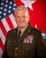 MG Jones command photo, sitting in front of American flag and two star flag in dress uniform