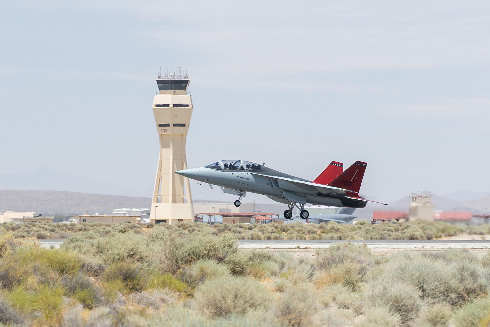 A T-7A Red Hawk departs Edwards Air Force Base on June 25, 2026, marking the first joint test sortie with both developmental and operational test aircrew aboard. The milestone positions the Airpower Foundations Combined Test Force at Edwards to begin combined developmental and operational test flights, ultimately accelerating capability for the warfighter. (Air Force photo by Christian Raterman)