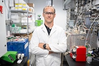 Matthew Yates, Ph.D., U.S. Naval Research Laboratory (NRL) research scientist, poses for a photo in the mobile biomanufacturing system in Washington, D.C., June 23, 2026. Scientists at NRL use the mobile system to develop, prototype, and test technologies for the manufacturing of Department of War-critical materials when and where they are needed. (U.S. Navy photo by Sarah Peterson)