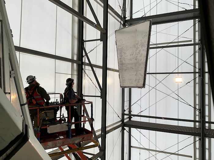 Construction workers raise panel