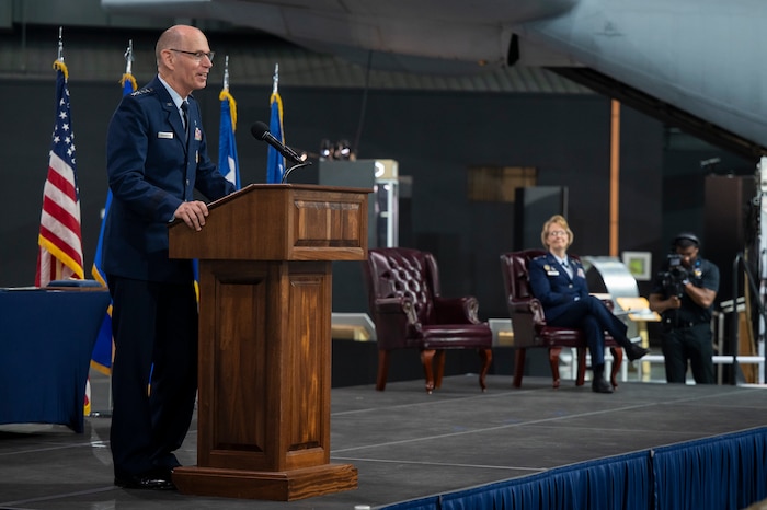 Male retired Air Force general wears dress blues and address crowd from a podium.