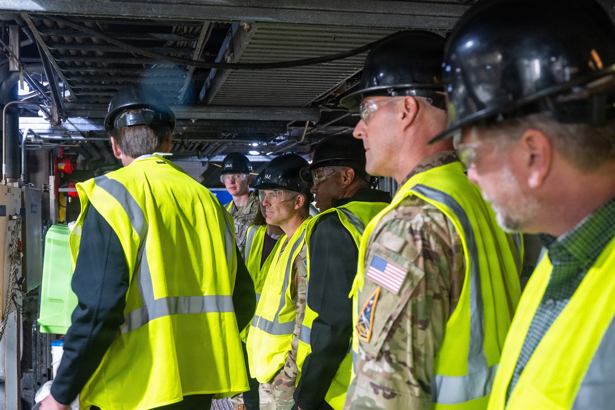 Men huddle around in safety gear.