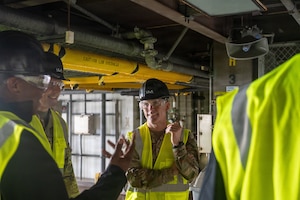 Men in Hi-Vis vests talk.