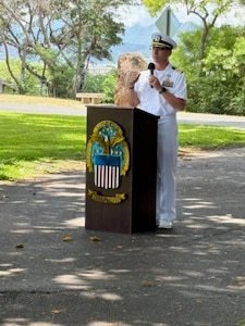 A Navy captain speaks at a podium.