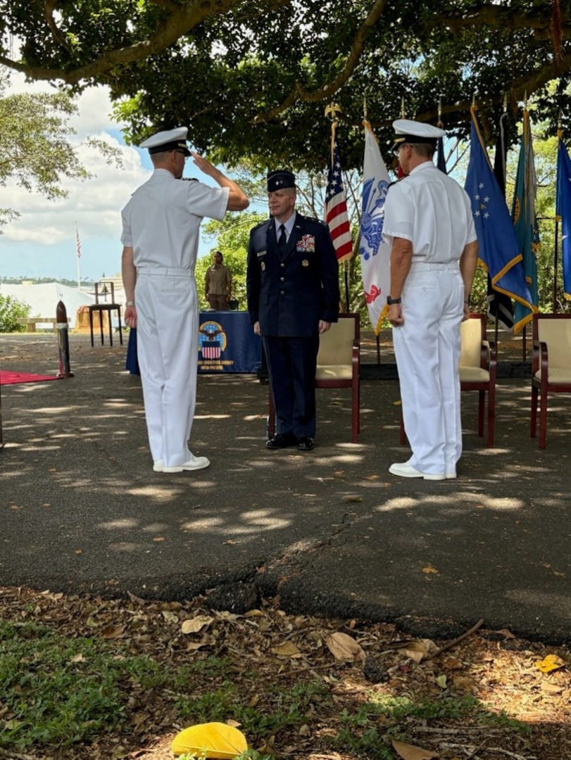 One Navy captain salutes an Air Force major general, while another Navy captain looks on.