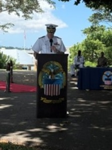 A Navy captain speaks at a podium.