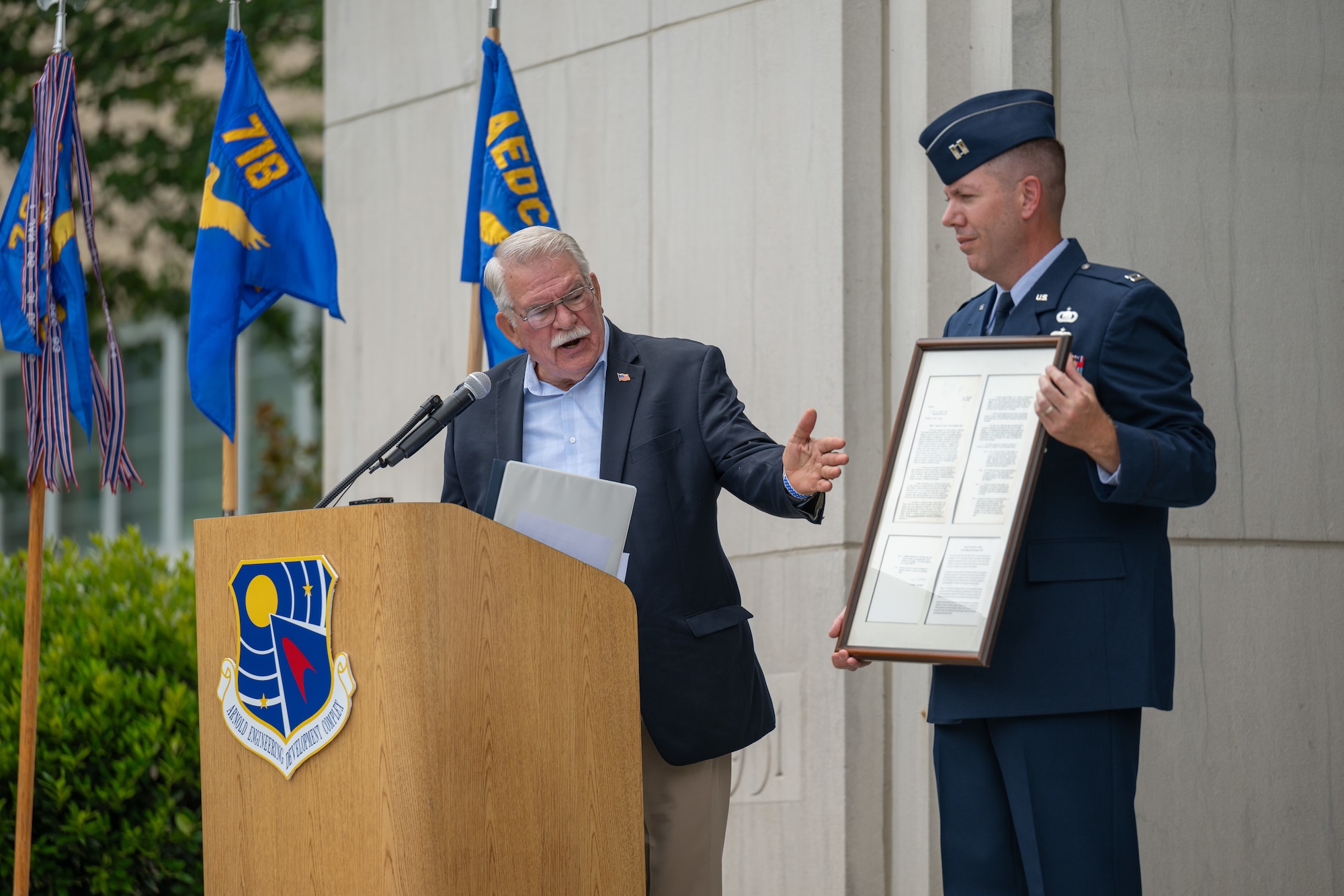 Retired Air Force Col. and former Arnold Engineering Development Complex commander Larry Graviss describes the requirements document written by Frank Wattendorf in the 1940s that he contributed to the AEDC time capsule unveiled June 27, 2026, during the AEDC 75th anniversary open house celebration at Arnold Air Force Base, Tenn., headquarters of AEDC. In the document Wattendorf detailed the facilities needed for a new test center. This center was later constructed and dedicated as Arnold Engineering Development Center on June 25, 1951. Holding the document is AEDC Executive Officer Capt. Nathan Tedder. (U.S. Air Force photo by Keith Thornburgh)