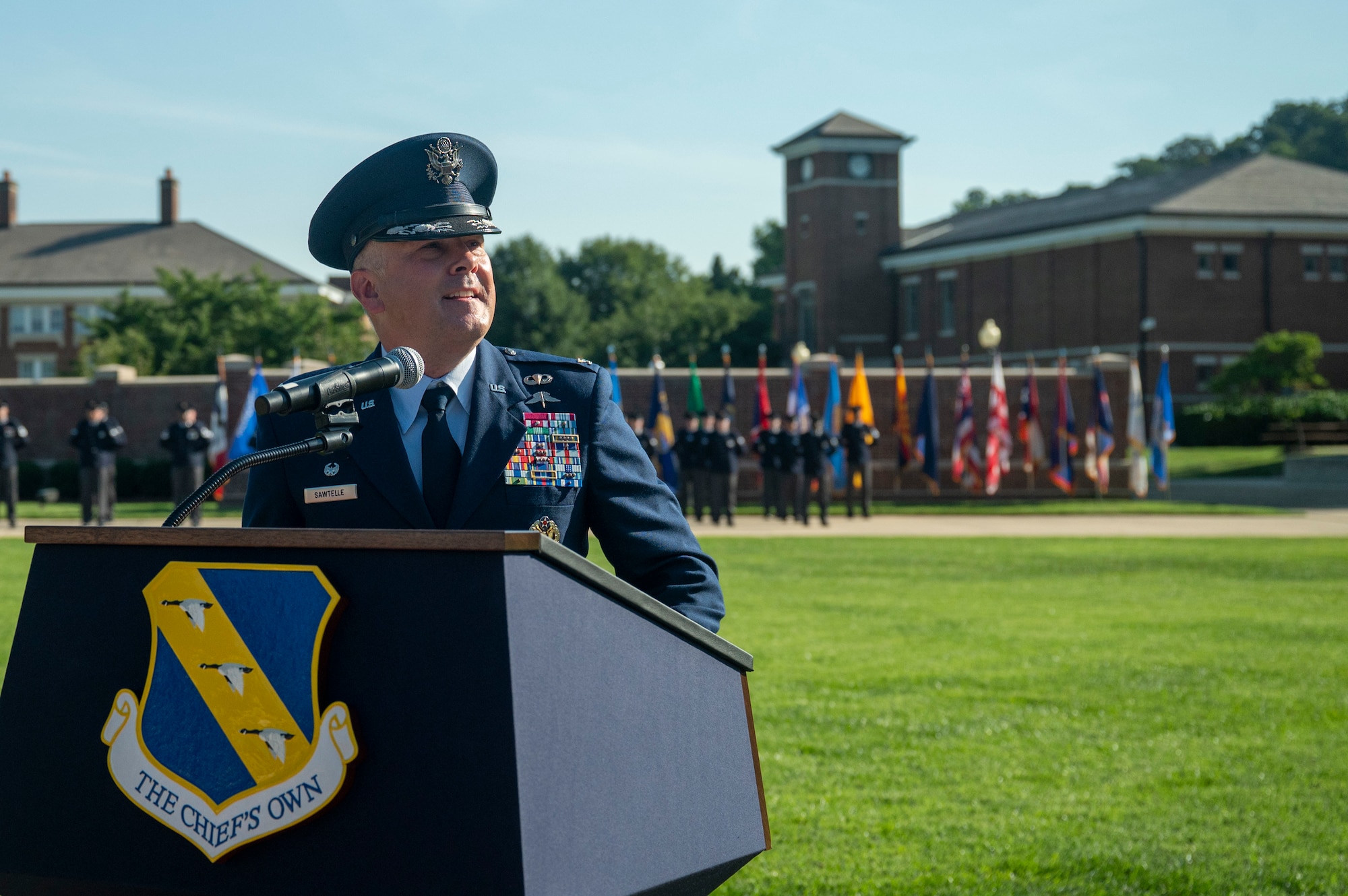 U.S. Air Force Col. stands behind a podium with The Chiefs Own symbol.