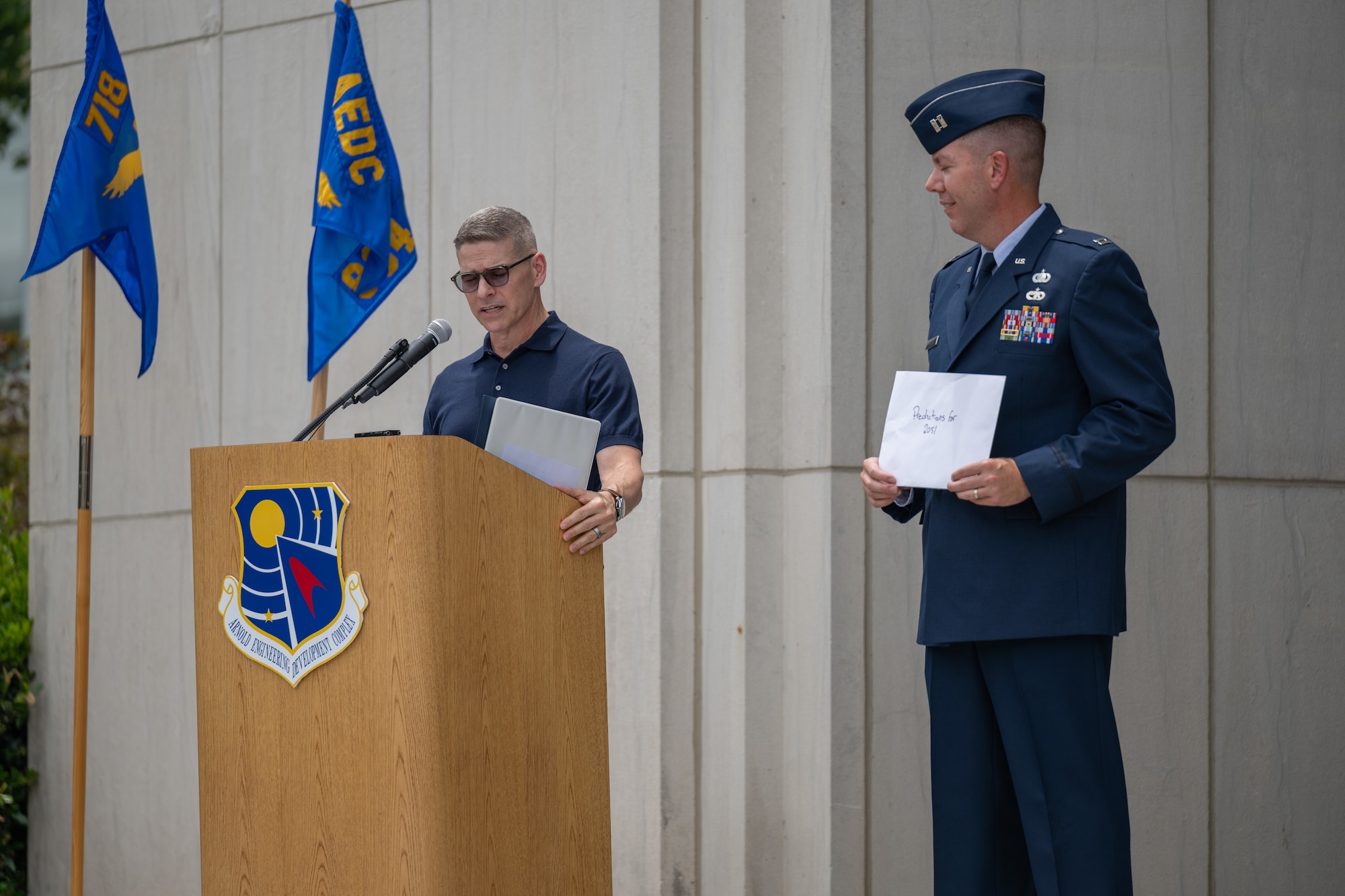 Retired Air Force Col. Raymond Toth, who served as Arnold Engineering Development Complex commander from 2012 to 2015 displays the written predictions for 2051, which will be the 100th anniversary of AEDC, he contributed to the AEDC time capsule unveiled June 27, 2026, during the AEDC 75th anniversary open house celebration at Arnold Air Force Base, Tenn., headquarters of AEDC. Pictured holding the document contributed by Toth is AEDC Executive Officer Capt. Nathan Tedder. (U.S. Air Force photo by Keith Thornburgh)