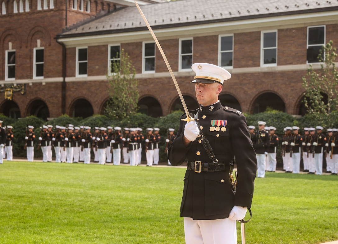 U.S. Marine Corps Capt. Hayden Brown, executive officer, Guard Company, Marine Barracks Washington, renders a salute during a change of command ceremony at Marine Barracks Washington, D.C., July 16, 2026. The ceremony included the passing of the organizational colors from the outgoing to the incoming commander, symbolizing the transfer of authority, responsibility, and accountability for the command, and featured marching and musical elements from Marine Barracks Washington. The ceremony took place as the “Oldest Post of the Corps” celebrates 225 years since its founding, a milestone that falls during America's 250th anniversary of independence and just one year after the Marine Corps 250th birthday.  (U.S. Marine Corps photo by Cpl. Brynn L. Bouchard)